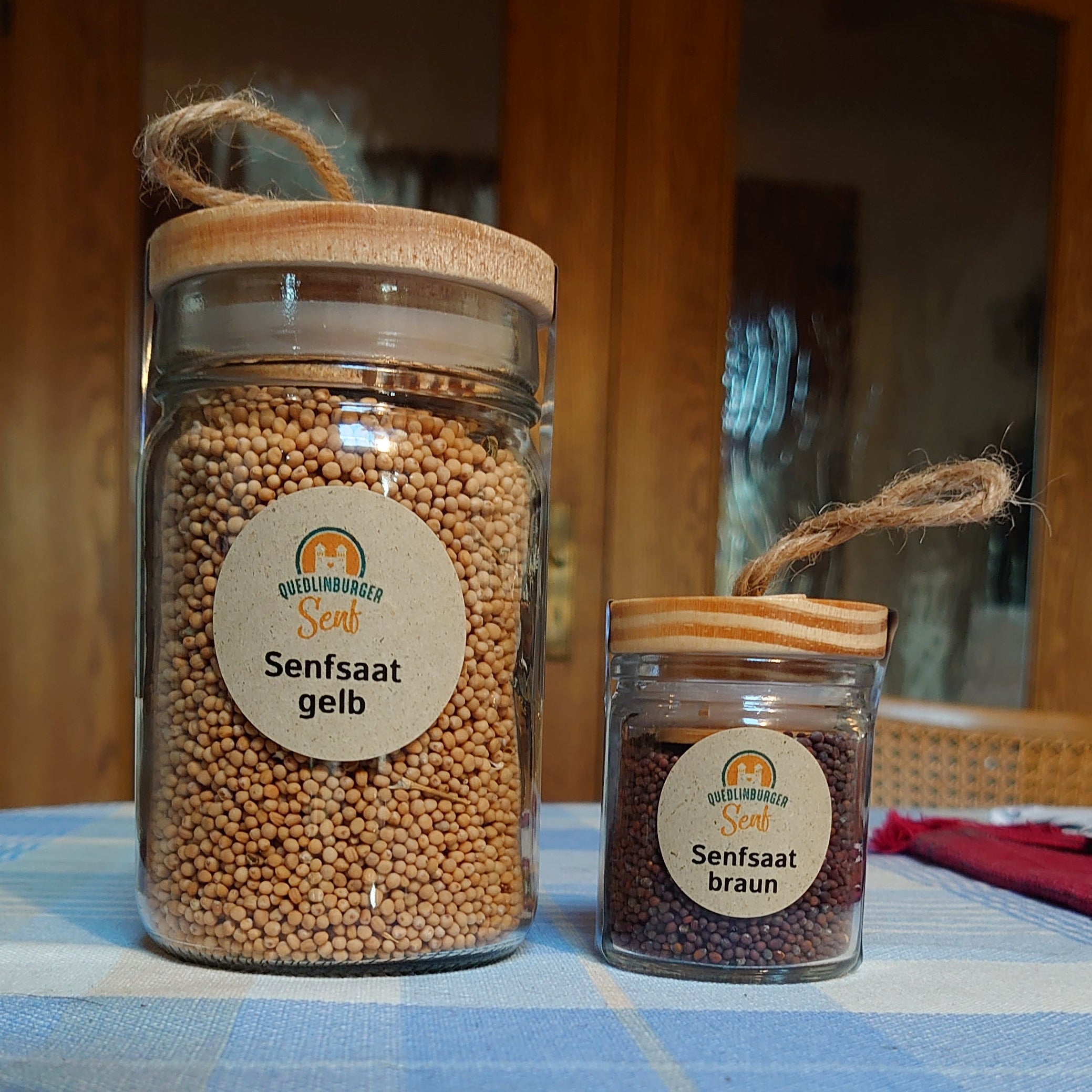 Zwei Gläser Pat & Patachon Senfsaat – groß und klein – stehen auf einem Küchentisch. Die wiederverwendbaren Gläser aus der Quedlinburger Senf-Manufaktur symbolisieren nachhaltigen Genuss und Handwerk aus dem Harz.