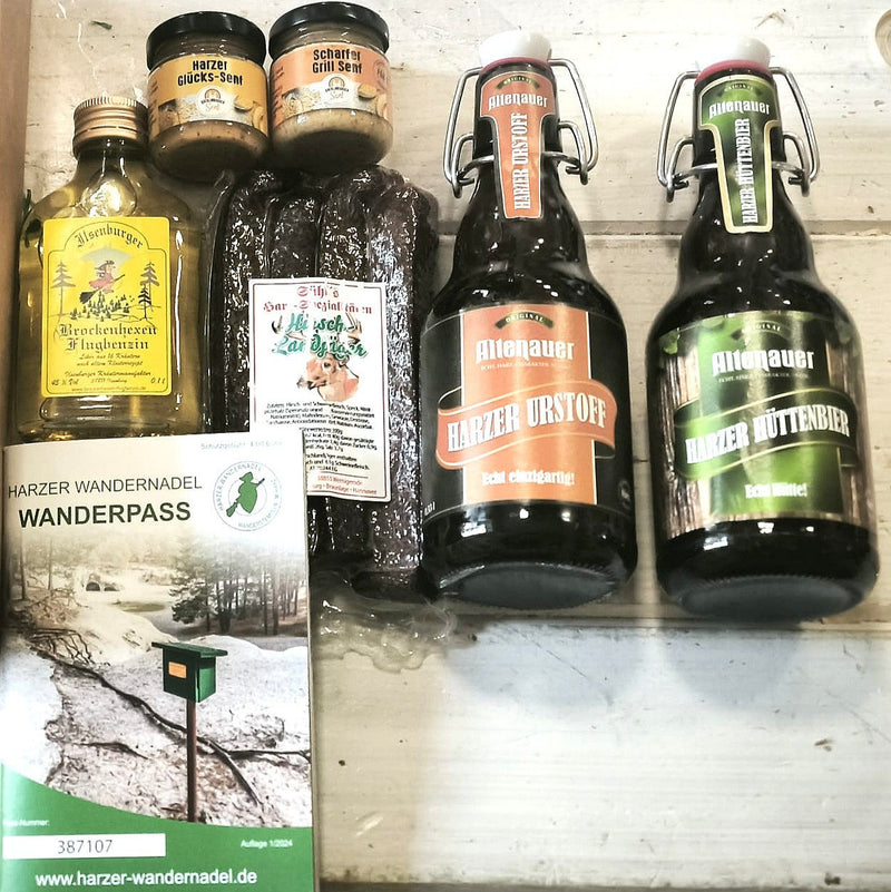 Inhalt der Harzer Wanderkiste: 2 Harzer Biere aus Altenau, 5x Hirschlandjäger, 2x Senfprobe aus unserer Manufaktur, 1x Brockenhexen-Flugbenzin, Harzer Wanderpass