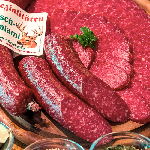 Hirschsalami aus dem Harz, luftgetrocknet, angeschnitten auf Holzbrett – rustikale Wildsalami in handwerklicher Qualität