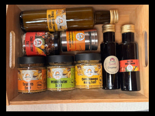 Unsere Jubiläums-Produkte: 3x Senf, scharfes Salz, milde Honig-Senf-Sauce, BBQ-Sauce und Gelenkschmiere in der Holzbox
