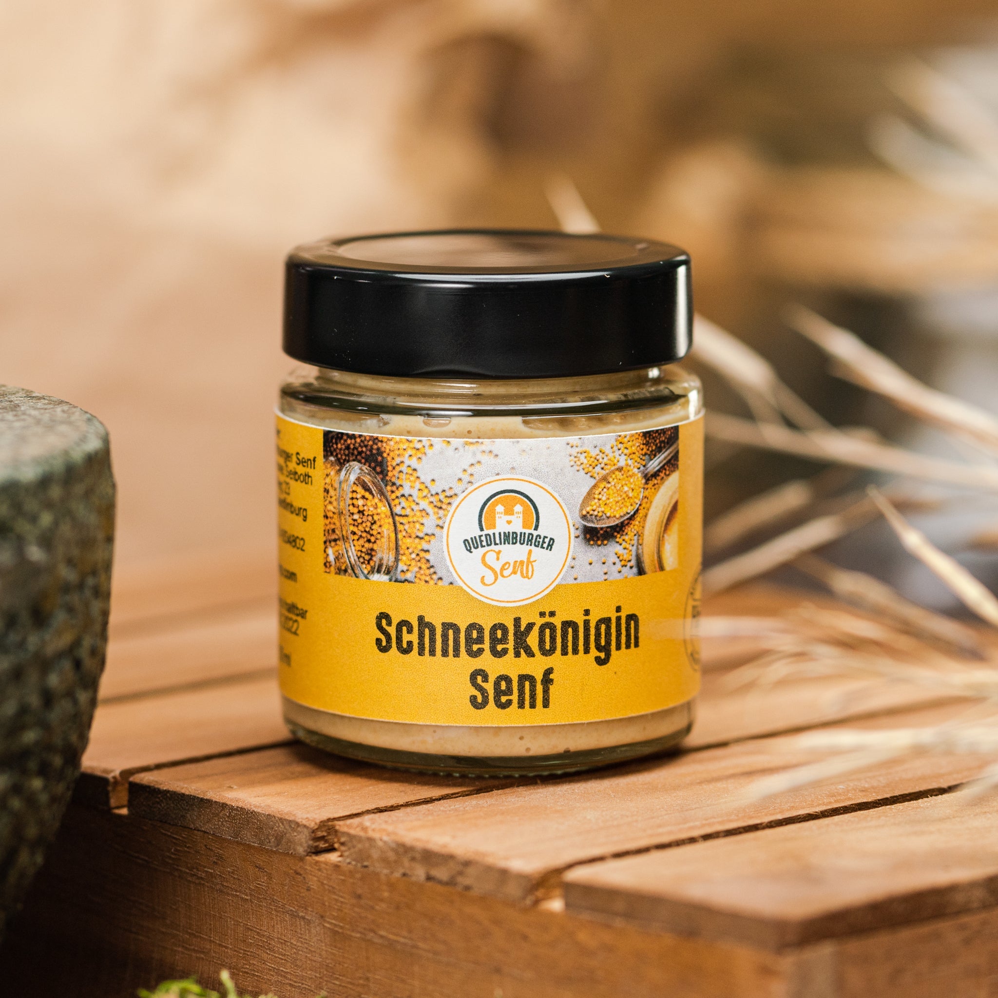 Glas Schneekönigin-Senf auf Holoztisch. Frischer, würziger Senf aus der Quedlinburger Manufaktur, inspiriert vom Märchen der Schneekönigin.