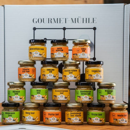 Senf-Mühlespiel mit 18 Mini-Senfgläsern, dekorativ angeordnet auf einem Holzbrett mit Senfgläschen als Spielsteinen. Genussvolles Spielset aus der Quedlinburger Senf-Manufaktur.
