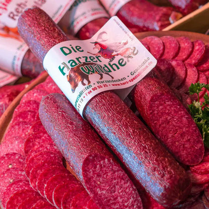 Wild-Hexe aus dem Harz, kräftige Wildsalami aus zwei Wildsorten, rustikal präsentiert auf Holzbrett